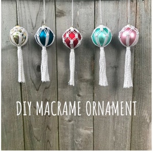 Peut inclure: Cinq ornements en macramé faits maison suspendus à une clôture en bois. Les ornements sont faits avec un cordon blanc et présentent une variété de couleurs, notamment l'or, le bleu sarcelle, le rouge, le turquoise et le rose.