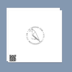 May include: A black and white logo with a stylized origami bird in a circle. The text around the circle reads "The Cardboard Crowl" and includes the website address "thecardboardcrowl.com" and the website URL "https://thecardboardcrowl.com".
