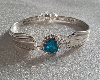 Vintage cutlery bracelet with an aqua blue heart shaped connector, safety chain and magnetic clasp.