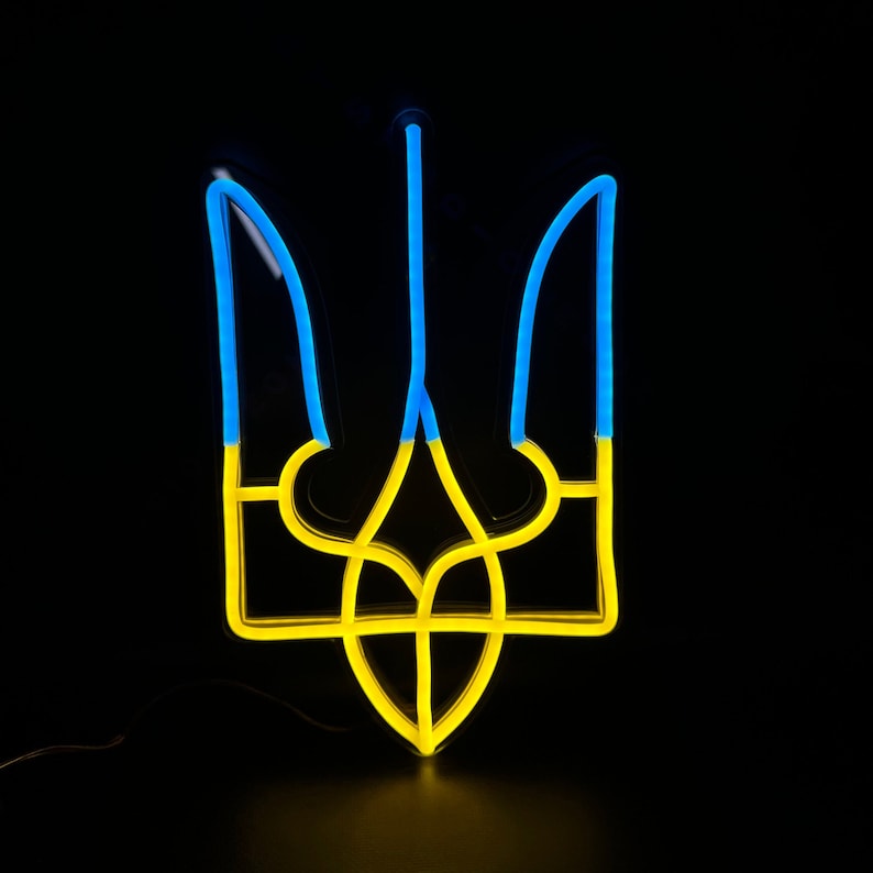 May include: A neon sign depicting the Ukrainian trident, a traditional symbol of Ukraine. The trident is yellow and blue, the colors of the Ukrainian flag.