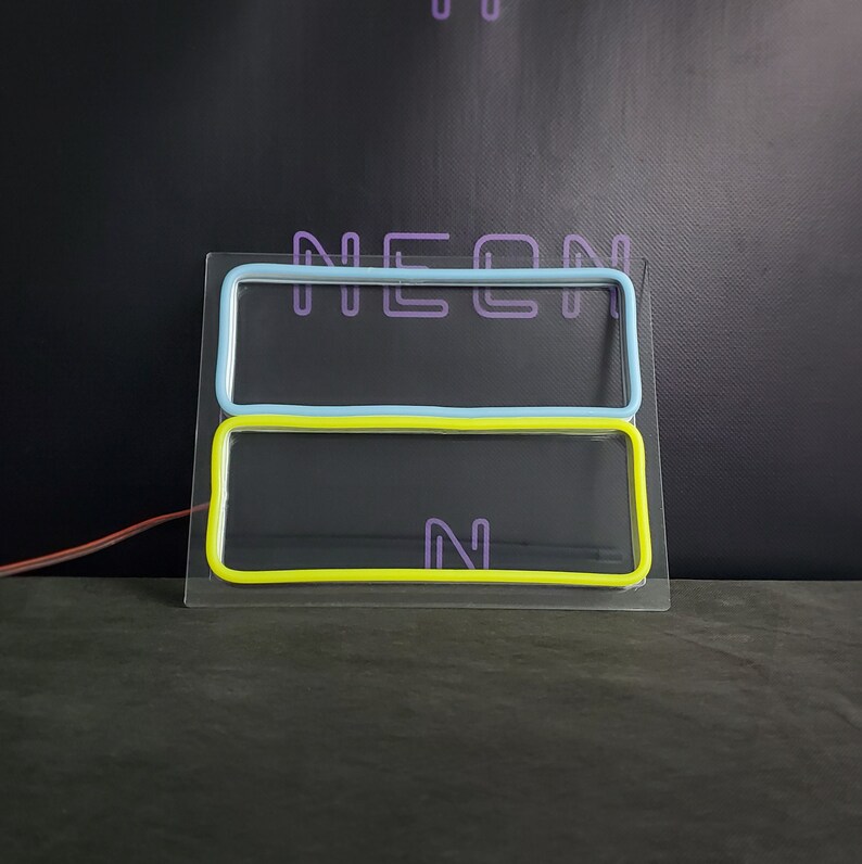 May include: A neon sign with the word "NEON" in purple, blue, and yellow. The sign is on a black background.