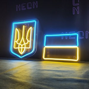 May include: Two neon signs, one depicting the Ukrainian coat of arms in yellow and blue, and the other a simple yellow and blue rectangle. Both signs are illuminated and have a clear plastic backing.