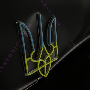 May include: A yellow, blue, and white neon sign of the Ukrainian trident, a traditional symbol of Ukraine.