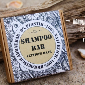 Könnte beinhalten: Eine braune Pappbox mit einem weißen Etikett, auf dem "Shampoo Bar - 0% Plastik - 100% Natürlich - 100% Biologisch - Abbauar - Fettigess Haar" in schwarzer Schrift steht. Das Etikett hat ein florales Design mit schwarzen und weißen Illustrationen.