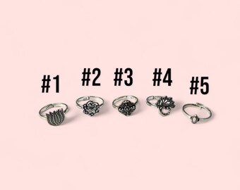 May include: Five silver toe rings with different designs. The rings are numbered 1 through 5.