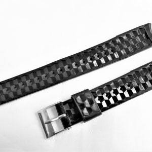 Puede incluir: Correa de reloj de caucho negro con un patr&oacute;n texturizado y una hebilla plateada.