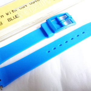 Könnte beinhalten: Ein hellblaues Armband mit einer Schließe. Das Armband besteht aus einem weichen, flexiblen Material. Das Armband ist mit "Resin With sat steel clasp 1.403 BLUE" beschriftet.