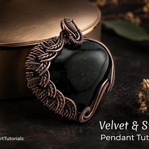 Könnte beinhalten: Ein herzförmiger Anhänger mit einem dunklen, glänzenden Stein in der Mitte, kunstvoll mit kupferfarbenem Draht umwickelt. Der Anhänger hängt an einer passenden Drahtschlaufe. Der Text "Velvet & Steel Pendant Tutorial" ist unten sichtbar.