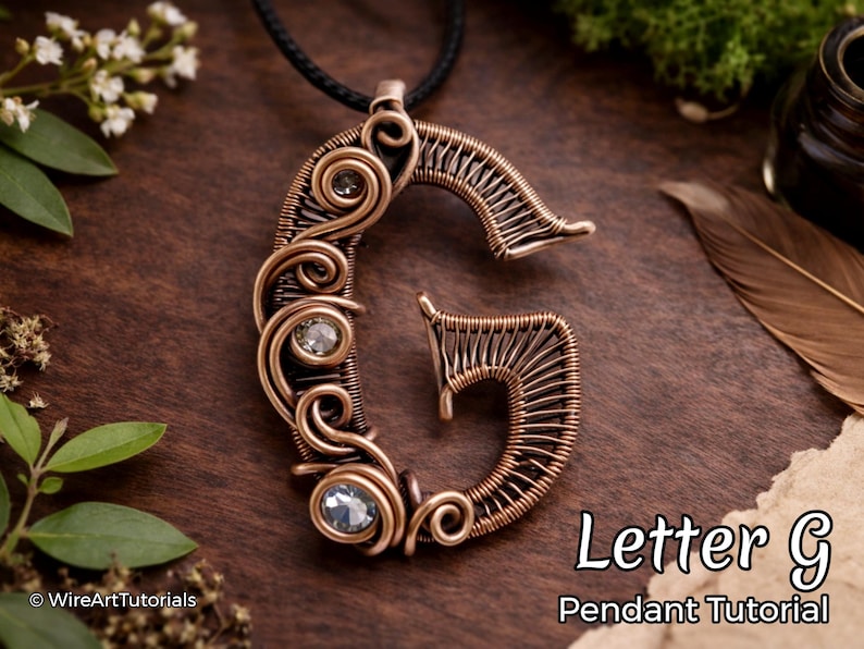 Może przedstawiać: Miedziany wisiorek z drutu w kształcie litery "G", ozdobiony przezroczystymi kamieniami szlachetnymi. Wisiorek wisi na czarnym sznurku. Widoczny jest tekst "Letter G Pendant Tutorial".