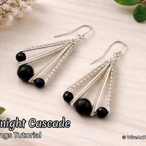 Op de afbeelding: Zilveren draad oorbellen met zwarte kralen. De oorbellen hebben een cascade-ontwerp, met drie draadstrengen en drie zwarte kralen. De tekst "Midnight Cascade Earrings Tutorial" is zichtbaar. Handgemaakte sieraden.