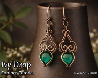 May include: A pair of copper-colored wire earrings with a teardrop-shaped green gemstone. The earrings have an ornate, swirling design and are suspended from a hook. The text "Ivy Drop Earrings Tutorial" is visible in the image.