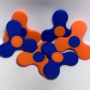 May include: A collection of fidget spinners in a vibrant color scheme. The spinners feature a three-lobed design with a central circular button. The color combination includes orange and blue, creating a visually appealing contrast.