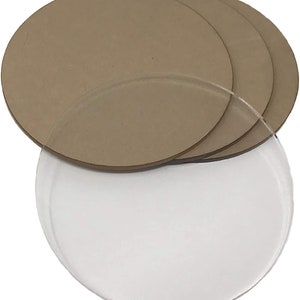 May include: Four brown round wooden discs stacked on top of each other. A clear round acrylic disc is underneath the wooden discs.