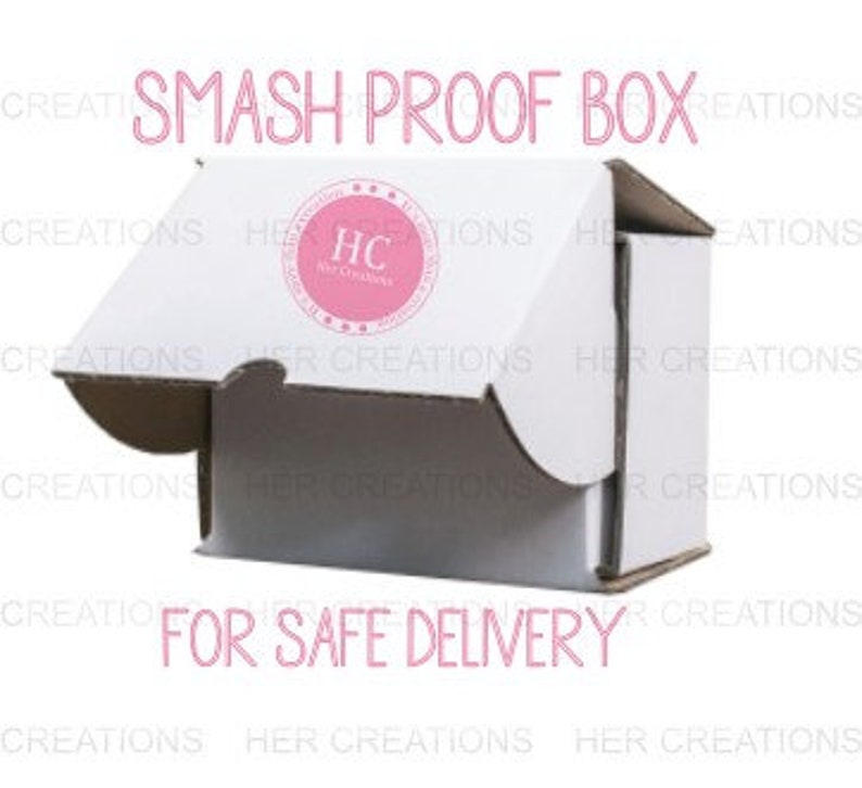 May include: A white cardboard box with the words "SMASH PROOF BOX" printed on the top. The box is open and the inside is visible. The words "FOR SAFE DELIVERY" are printed on the bottom of the box.