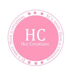 May include: A pink circle with white text that reads "It's more than a creation" and "It's more than a creation" in a circular pattern. The text "HC Her Creations" is in the center of the circle.