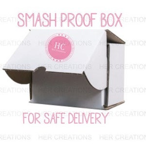 May include: A white cardboard box with the words "SMASH PROOF BOX" printed on the top. The box is open and the inside is visible. The words "FOR SAFE DELIVERY" are printed on the bottom of the box.