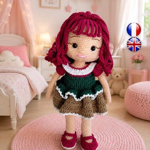 May include: A handmade crochet doll with dark red yarn hair, featuring a beige complexion, black embroidered eyes, and a pink stitched mouth. The doll wears a dark green top with a white ruffled collar and a brown skirt with a white hem, plus red shoes.