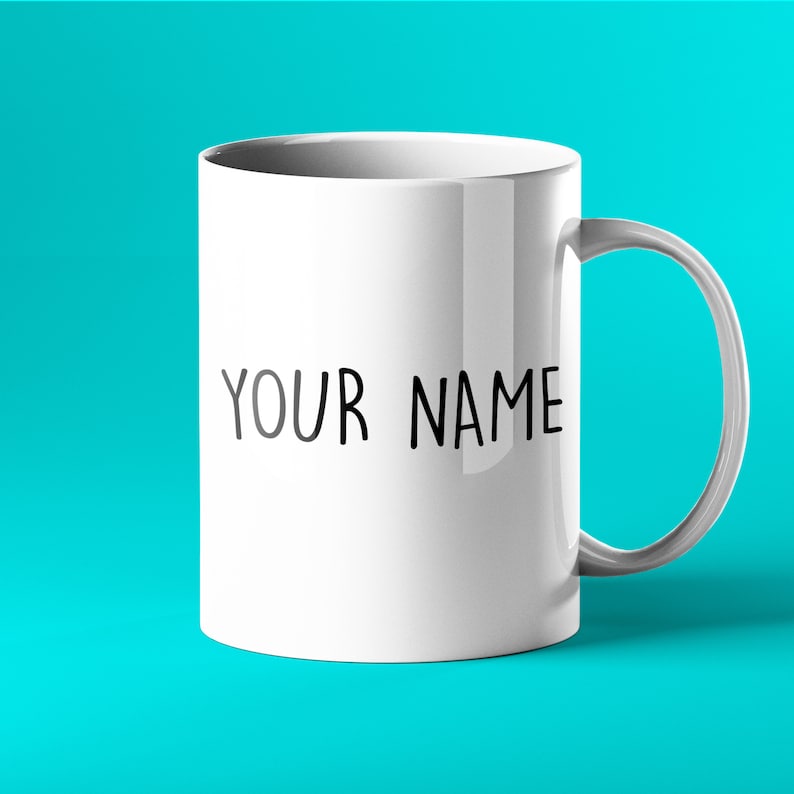Pu&ograve; includere: Una tazza in ceramica bianca con un manico nero e il testo "YOUR NAME" stampato sul davanti.