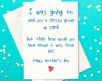 May include: A white card with blue handwritten text that reads "I was going to send you a classy grown up card but then how would you have known it was from me? Happy mother's day". A red heart is drawn at the bottom of the card.