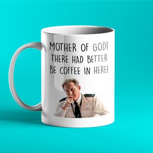 Op de afbeelding: Witte keramische mok met een zwart-witte afbeelding van een man in politiekostuum. Op de mok staat de tekst "Mother of God! There had better be coffee in here!" gedrukt.