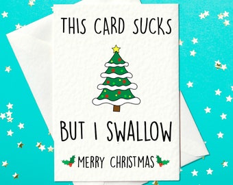 May include: A white Christmas card with the text "THIS CARD SUCKS BUT I SWALLOW MERRY CHRISTMAS" and a cartoon Christmas tree. The card is inside a white envelope, set against a teal background with scattered star-shaped confetti.