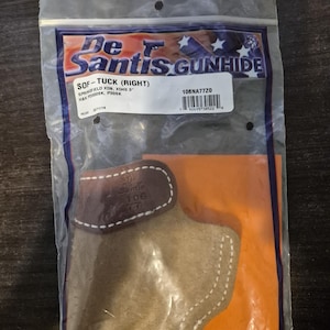 May include: A De Santis Gunhide SOF-TUCK (RIGHT) holster for Springfield XD, XD40 3", H&K P2000SK, and P30SK firearms. The holster is tan with a brown leather accent and white stitching, packaged in a clear plastic bag.