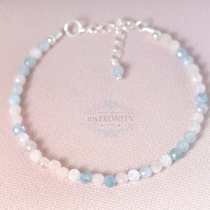 May include: A delicate bracelet made with light blue and pink gemstone beads. The bracelet has a silver clasp and is perfect for everyday wear.