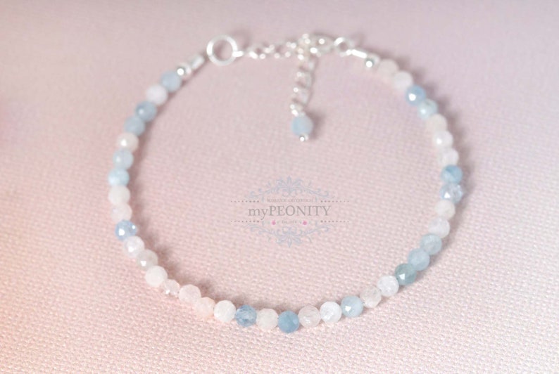 May include: A delicate bracelet made with light blue and pink gemstone beads. The bracelet has a silver clasp and is perfect for everyday wear.