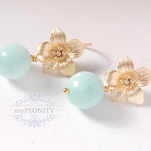 May include: Gold flower earrings with light blue round gemstone beads.