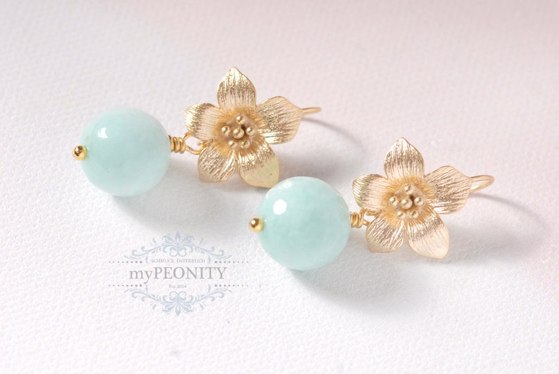May include: Gold flower earrings with light blue round gemstone beads.