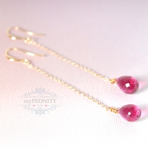 Puede incluir: Un par de pendientes de oro con piedras preciosas de color rosa en forma de lágrima.