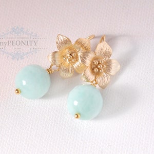 May include: Gold flower earrings with light blue round gemstone drops.