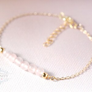 Puede incluir: Un delicado brazalete de cadena dorada con una fila de cuentas de color rosa p&aacute;lido. El brazalete es simple y elegante, perfecto para el uso diario.