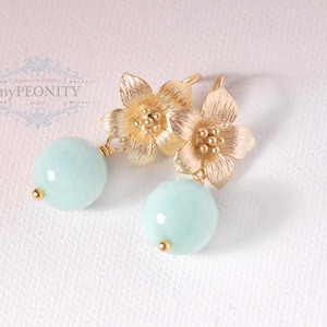 May include: Gold flower earrings with light blue round gemstone drops.