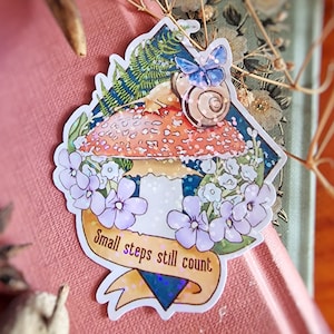 Grand sticker coloré et brillant représentant un escargot et un papillon dans une amanite. | Adorable papeterie en cottagecore, esthétique féerique.