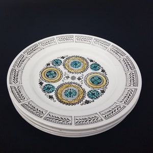 Peut inclure: Un ensemble de quatre assiettes plates en céramique blanche avec une bordure noire et blanche et un motif central de cercles jaunes et turquoise avec des accents noirs et blancs.