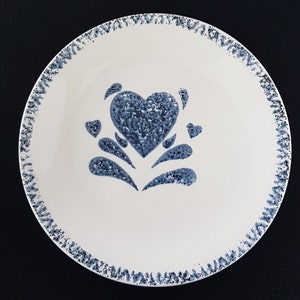 May include: A white ceramic plate with a blue and white heart design. The plate has a scalloped edge.