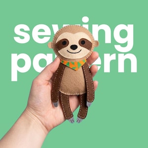 May include: A handmade felt sloth toy with a light brown face, dark brown eyes, and a smiling mouth. The sloth has a brown body, arms, and legs, and wears an orange and green patterned scarf. The words "sewing pattern" are in white text.