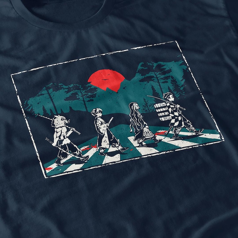 May include: Navy blue t-shirt featuring a graphic of four anime characters crossing a street, with a red sun and forest background. The design is a parody of the iconic Abbey Road album cover. The characters are holding swords.