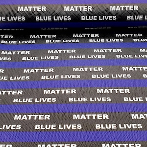 May include: A close-up of a blue and black fabric with the repeated text "Matter" and "Blue Lives" printed in white.