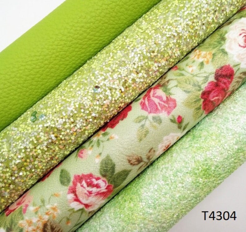 May include: Close-up of four rolls of fabric in shades of green. The rolls include a textured lime green, a glittery light green, a floral print with red roses, and a speckled light green. The text "T4304" is visible in the bottom right corner.