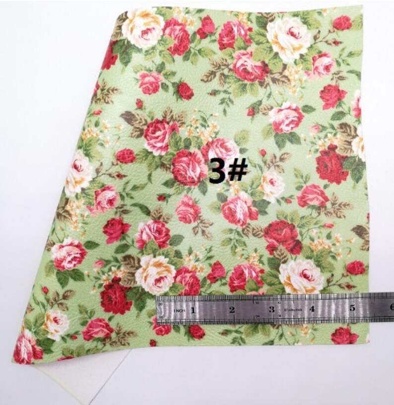 May include: A sheet of floral patterned material featuring red and white roses on a light green background. The text "3#" is visible. A ruler shows the material is approximately 6 inches wide.