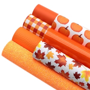 May include: A set of five orange faux leather sheets with different patterns. The patterns include a plaid, a pumpkin, a fall leaf, and a glitter texture.