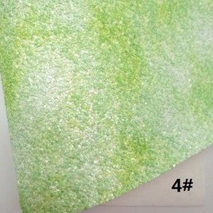 May include: Close-up of a sheet of green glitter fabric. The fabric has a textured surface with small, round, light green sequins. The number "4#" is visible in the bottom right corner.