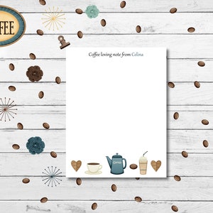 May include: A white notepad with a coffee-themed design. The notepad has a brown wooden background with coffee beans scattered around the edges. The top of the notepad says "Coffee loving note from Celina". The bottom of the notepad has a coffee pot, a cup of coffee, a coffee to-go cup, and two hearts.