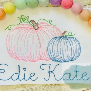 Puede incluir: Dise&ntilde;o bordado de dos calabazas, una rosa y una azul, con los nombres "Edie Kate" cosidos debajo.