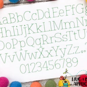 Pu&ograve; includere: Uno sfondo bianco con un alfabeto e numeri ricamati in verde. Le lettere sono in un carattere semplice e classico. Le lettere sono maiuscole e i numeri sono in un carattere standard.