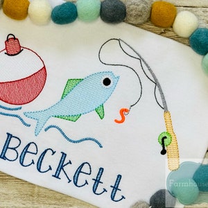 Puede incluir: Dise&ntilde;o bordado de una ca&ntilde;a de pescar, un pez, un flotador y el nombre Beckett. El dise&ntilde;o est&aacute; en tonos de azul, verde, rojo y naranja sobre un fondo blanco.