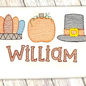 May include: Embroidered Thanksgiving design featuring a brown and blue headdress, an orange pumpkin, and a brown pilgrim hat with a yellow buckle. The name "William" is embroidered below the design.