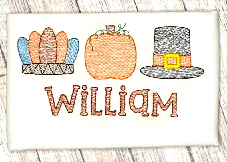 May include: Embroidered Thanksgiving design featuring a brown and blue headdress, an orange pumpkin, and a brown pilgrim hat with a yellow buckle. The name "William" is embroidered below the design.